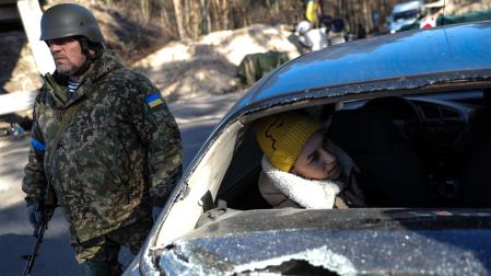 Una mujer dentro de un coche dañado en Kiev