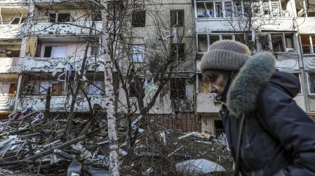 Una mujer pasa por delante de un edificio dañado por los bombardeos en Kiev