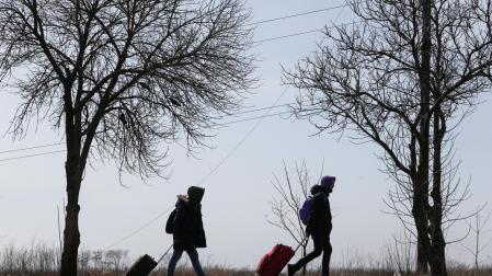 Refugiados caminan por una carretera saliendo de Mariupol