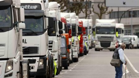 Un grupo de transportistas gallegos circulan con más de un centenar de camiones y vehículos agrarios, haciendo sonar la bocina para protestar por el alza de los precios del combustible, este lunes en Santiago de Compostela