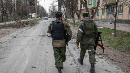 Dos soldados caminan hacia el frente en Mariupol