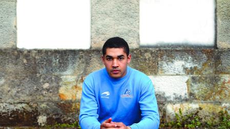 El zaguero Aarón Arbizu posa sentado en las inmediaciones de la parroquia de Santa María de Etxarri Aranatz