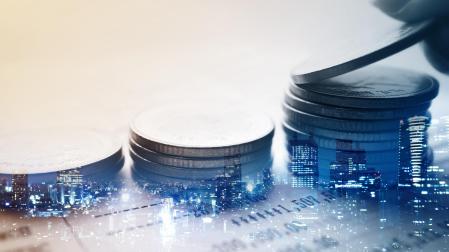 Double exposure of city and rows of coins for finance and banking concept