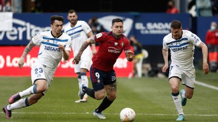 El delantero argentino del Osasuna, Chimy Ávila lucha por el balón con el defensa Ximo Navarro del Alavés