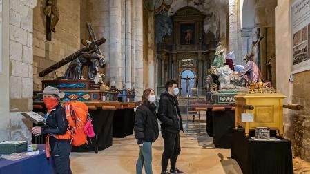 Visitantes ayer en el Santo Sepulcro y, a la derecha, el paso que hoy no saldrá en la procesión