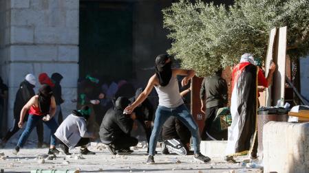 Jóvenes palestinos lanzan piedras a la policía israelí en la Explanada de las Mezquitas, en Jerusalén