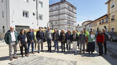 Representantes municipales y vecinos posan junto a las viviendas que serán rehabilitadas en la Txantrea