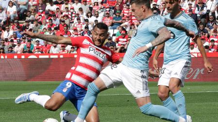 Luis Suárez, delantero del Granada, se lanza al suelo para pelear por el balón con un jugador del Celta