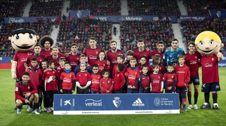 Niños de la Fundación Osasuna con el equipo titular que se enfrentó al Real Madrid en El Sadar
