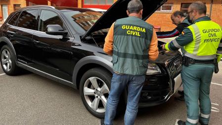 Agentes de la Guardia Civil inspeccionan el motor de uno de los vehículos implicados en la red de venta