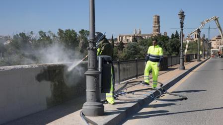 Un operario trabaja en la limpieza del puente, en el que se aprecia cómo está cambiando su color al retirar la suciedad acumulada