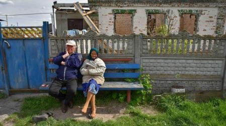 Dos personas descansan en un banco en el pueblo de Zahaltsi cerca de Kiev
