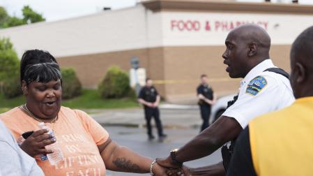 Un oficial de policía habla con una mujer cerca de la escena del asesinato múltiple en un supermercado de Búfalo (Nueva York)