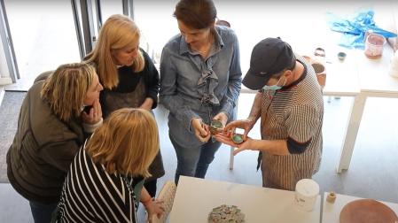 Dos alumnos muestran sus creaciones a Estrella Los Arcos (tercera por la izquierda)