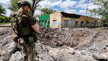 Un soldado ucraniano inspecciona un enorme agujero de un ataque aéreo ruso