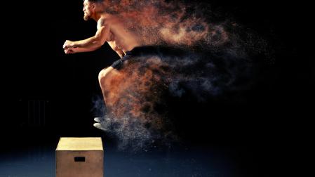 Un hombre saltando el cubo durante un entrenamiento de Crossfit