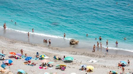 Varias personas disfrutan de la playa de la Rijana (Castell de Ferro)