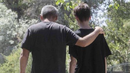 Un padre y un hijo pasean por un camino