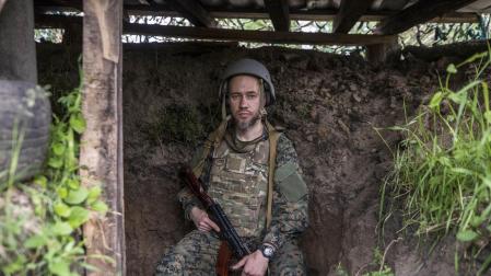 El soldado 'Den' posa en una trinchera en un bosque de Ucrania