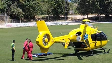 Un agente de la Guardia Civil junto a sanitarios en el césped del campo de fútbol de Miranda de Arga donde aterrizó el helicóptero