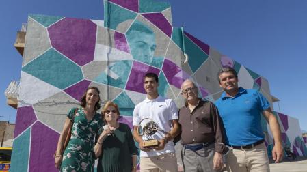 Carlos Alcaraz posa junto a su familia delante del grafiti