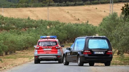 Un coche de la Policía Foral y otro de los servicios funerarios abandonan la finca de la empresa láctea Señorío de Sarriá tras el accidente laboral que costó la vida a dos trabajadores
