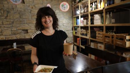 Natalia Ecay, dueña del restaurante La Antigua Farmacia, sujeta dos envases con comida para llevar