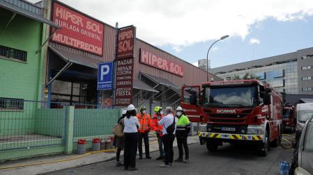 La fachada del edificio destruido por el incendio del día anterior y los técnicos que asesoran la condición de las instalaciones