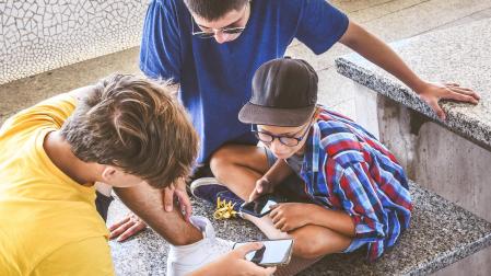 Varios adolescentes consultan el móvil