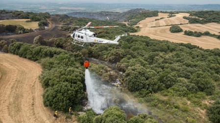 Un helicóptero vierte agua para sofocar el fuego, en un incendio anterior