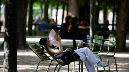 Una joven se abanica en los Jardines de Luxemburgo, en París