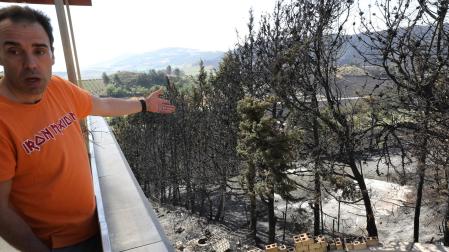 Pablo San Martín muestra el terreno afectado en Obanos por el incendio del sábado, que quemó la casa de al lado y prendió el jardín y una terraza con césped artificial de la suya