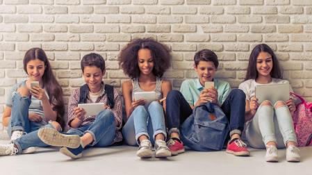 Los adolescentes sentados junto a sus amigos pero usando el móvil o la tablet en lugar de mantener conversaciones cara a cara