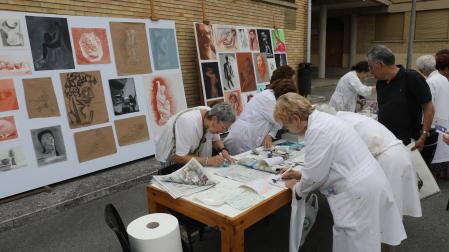 Alumnas de la escuela trabajando en sus obras. Al fondo, las obras de arte de los alumnos del curso de Pintura