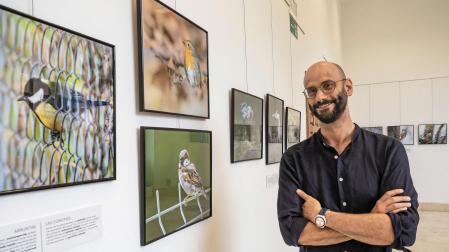 Xabier Elizalde junto a varias fotografías que se pueden contemplar estos días en la exposición de la casa de cultura Fray Diego de Estella