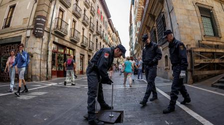 -Efectivos de la Unidad de Subsuelo de la Policía Nacional cierran la tapa de acceso de la calle Estafeta a los túneles del alcantarillado de Pamplona después de comprobar su interior.