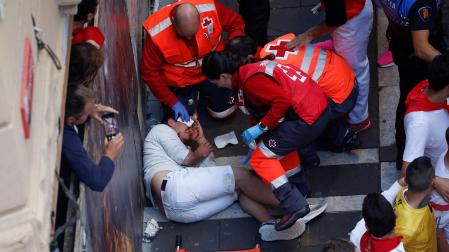 Servicios sanitarios atienden a un herido en el encierro