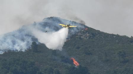 Un hidroavión anfibio contra incendios echa agua sobre la vegetación en la comarca de Las Hurdes