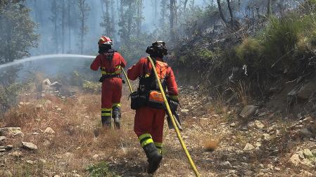 Dos efectivos de la Unidad Militar de Emergencias (UME) colaboran en la extinción del fuego en el Jerte