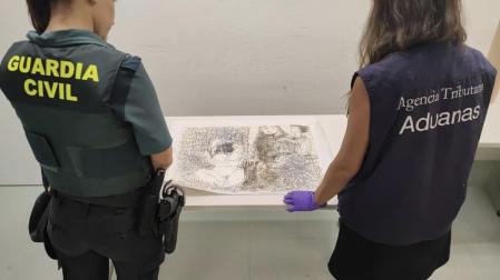 Dos agentes, de la Guardia Civil y Aduanas, junto a la obra "Trois personnages" (1966) que se encontraba en el equipaje de un viajero procedente de Suiza