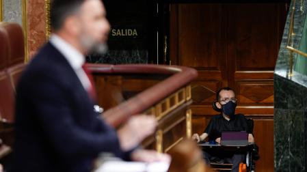 El portavoz de Unidas Podemos, Pablo Echenique (d), escucha la intervención del líder de Vox, Santiago Abascal, en el Congreso de los Diputados