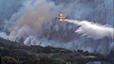 Uno de los hidroaviones que participan en el operativo descarga agua sobre el incedio de Los Realejos (Tenerife)