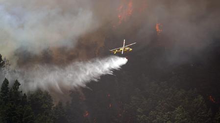 Un helicóptero contra incendios descarga agua sobre un incendio forestal en Tenerife