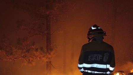 Un efectivo de la EIRIF trabaja en las labores de extinción del incendio de Tenerife durante la noche