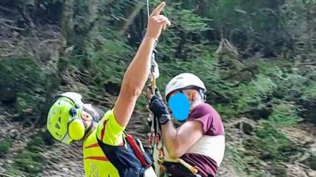 Un momento del rescate en el que bombero y herido son izados del barranco por el helicóptero