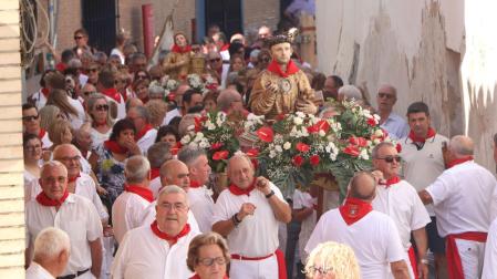 Las imágenes de San Esteban y Santa Bárbara, rodeadas de vecinos durante su desfile procesional