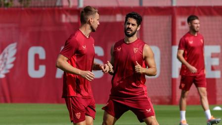 El centrocampista malagueño del Sevilla Isco Alarcón conversa con Rakitic durante el entrenamiento de este martes en el estadio Sánchez Pizjuán