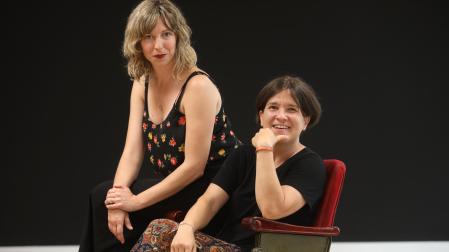 La actriz Leire Ruiz (izq.) y la directora teatral Laura Laiglesia, sentadas en la butaca que da nombre a la escuela de interpretación.