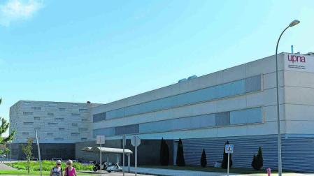 Dos mujeres pasean por los aledaños del campus de Tudela, con la Universidad de fondo
