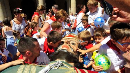 Un grupo de niños se despide de la figura de uno de los gigantes entre besos y caricias cuando los miembros de la comparsa lo tumbaron antes de guardarlos